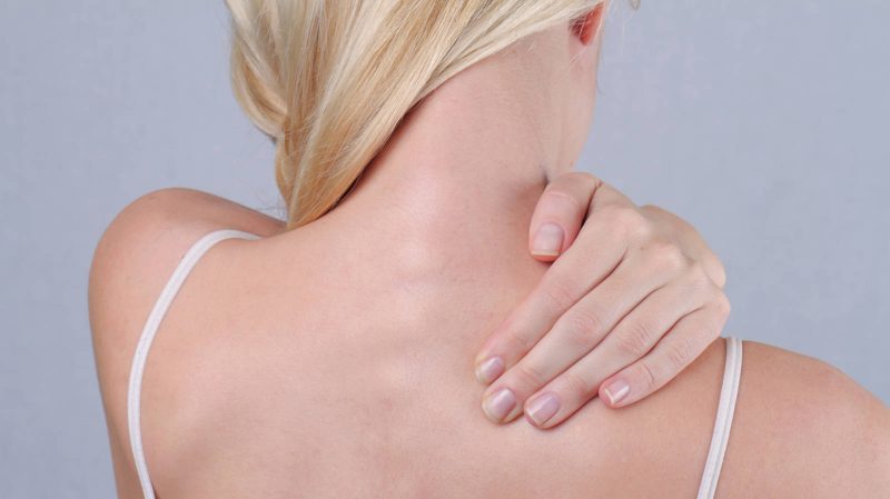 Woman with neck and back pain. Woman rubbing his painful back close up. Pain relief concept Woman with whiplash injury
